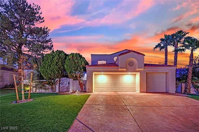 mediterranean / spanish house with a lawn and a garage