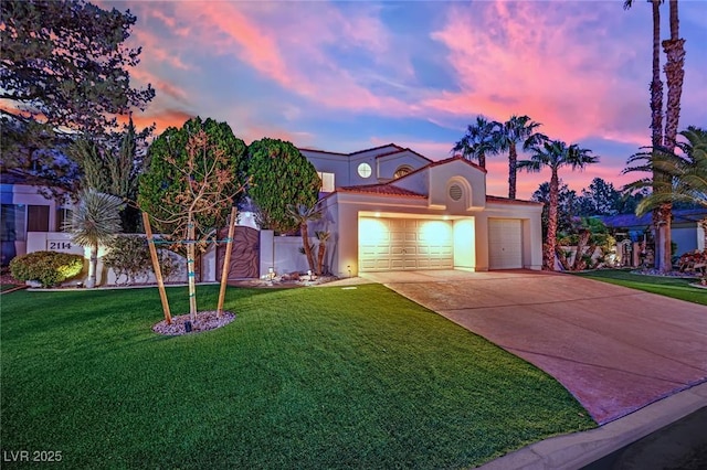 mediterranean / spanish-style house with a garage and a yard