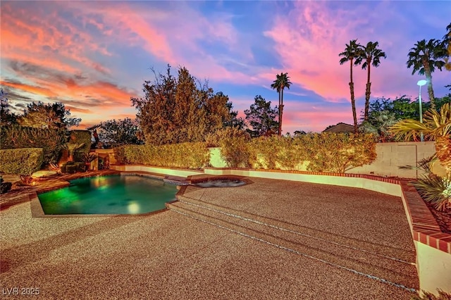 pool at dusk featuring a patio