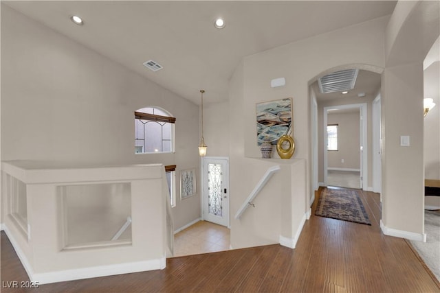 entryway with hardwood / wood-style floors and vaulted ceiling