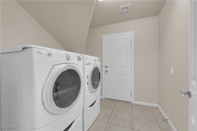 clothes washing area with separate washer and dryer and light tile patterned floors