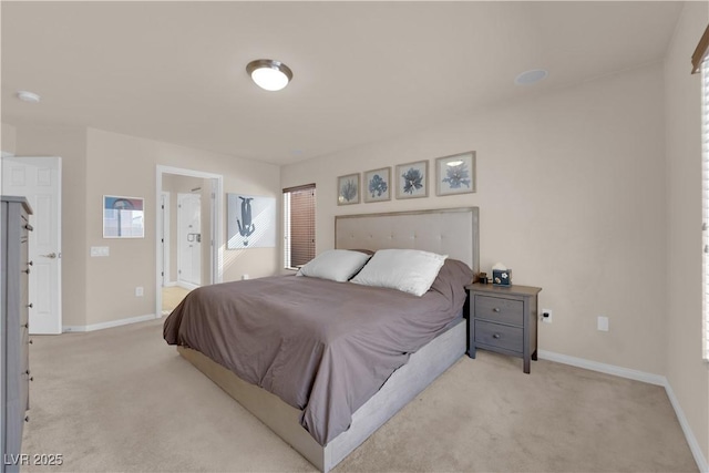 bedroom featuring ensuite bathroom and light carpet