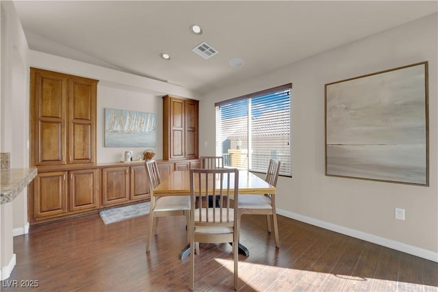 dining room with vaulted ceiling and dark hardwood / wood-style flooring