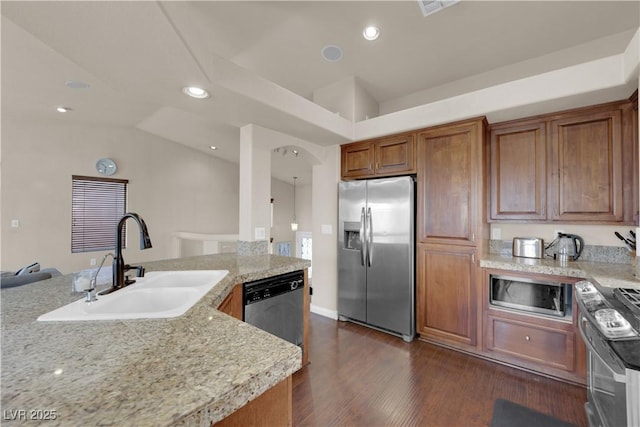 kitchen with vaulted ceiling, dark hardwood / wood-style floors, sink, light stone countertops, and stainless steel appliances