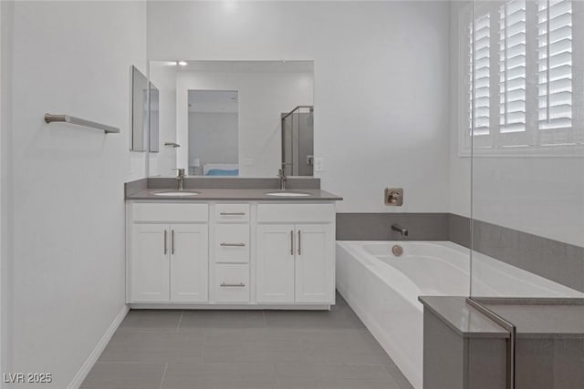 bathroom with vanity, tile patterned flooring, and a bath