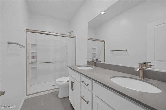 bathroom featuring tile patterned flooring, toilet, a shower with door, and vanity