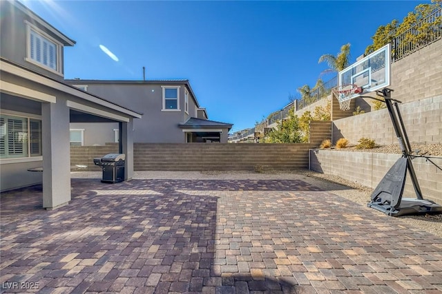 view of patio / terrace with area for grilling and basketball hoop