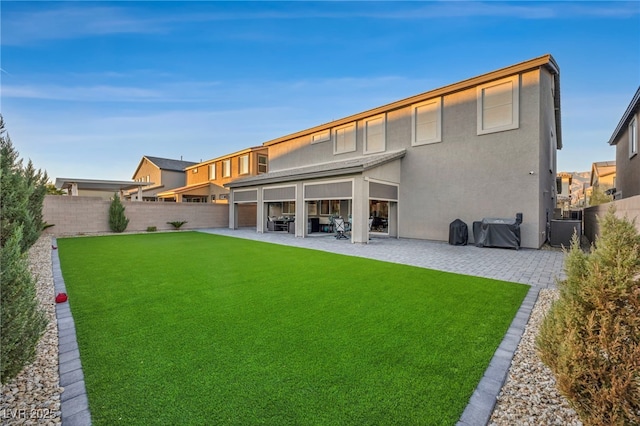 back of house with a lawn and a patio