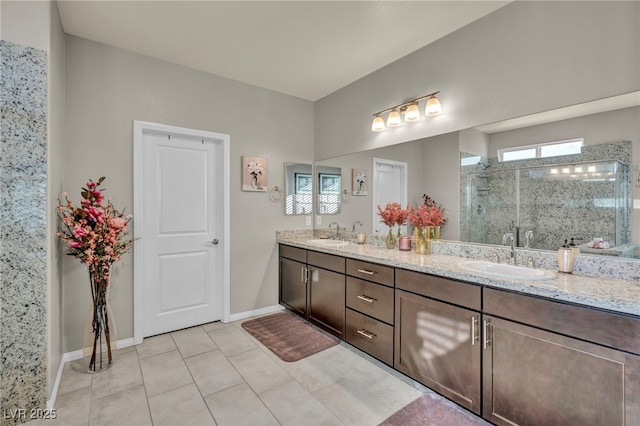 bathroom with a shower with shower door, vanity, and tile patterned flooring