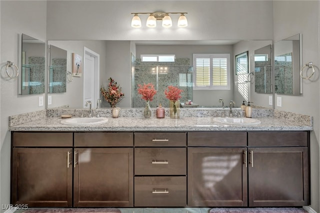 bathroom with a shower with shower door and vanity