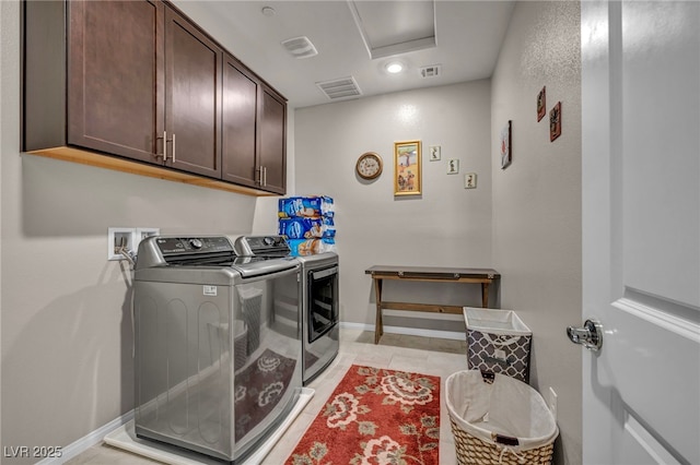 washroom featuring light tile patterned floors, independent washer and dryer, and cabinets