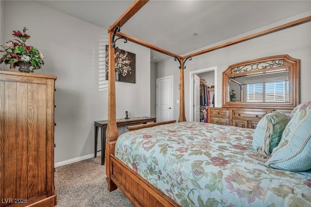 bedroom with a closet, a walk in closet, and light colored carpet