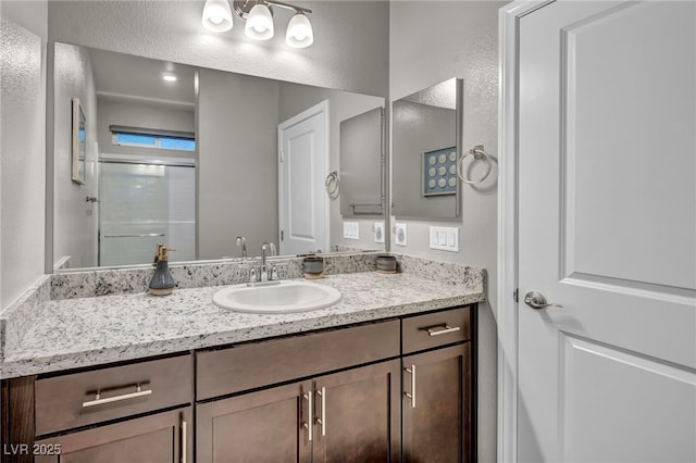 bathroom featuring vanity and an enclosed shower