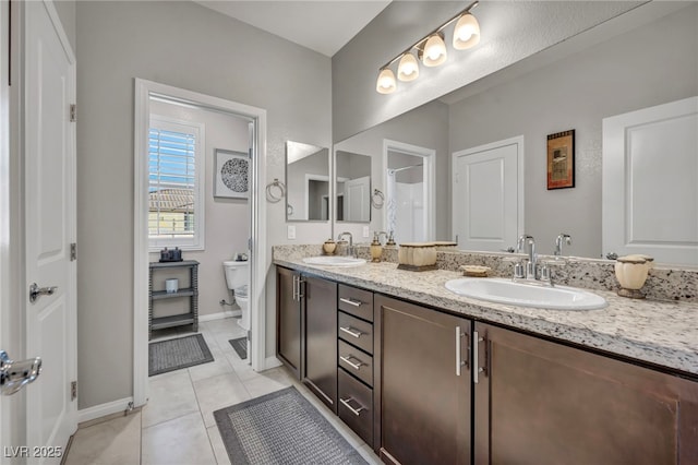 bathroom with toilet, tile patterned floors, and vanity