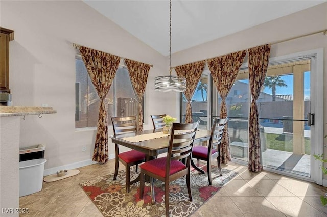 tiled dining space featuring lofted ceiling and a healthy amount of sunlight