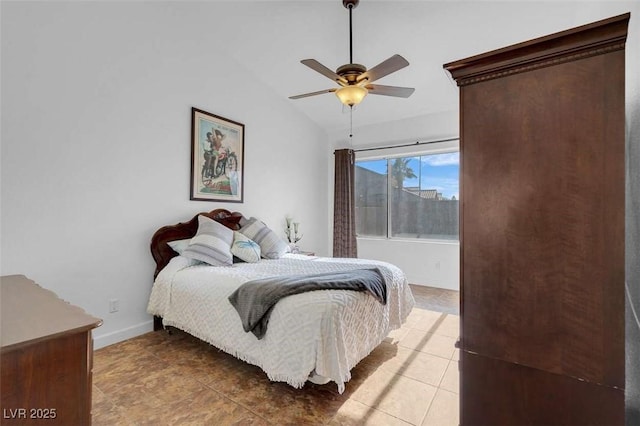 bedroom featuring ceiling fan, light tile patterned floors, and lofted ceiling