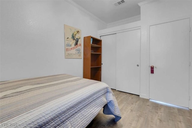 bedroom featuring ornamental molding and light hardwood / wood-style floors