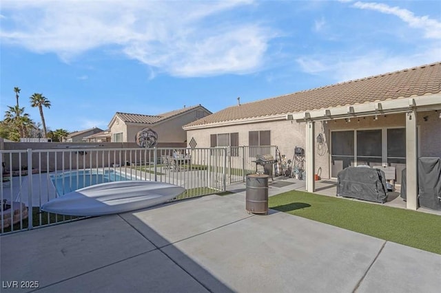 back of property with a patio area and a fenced in pool