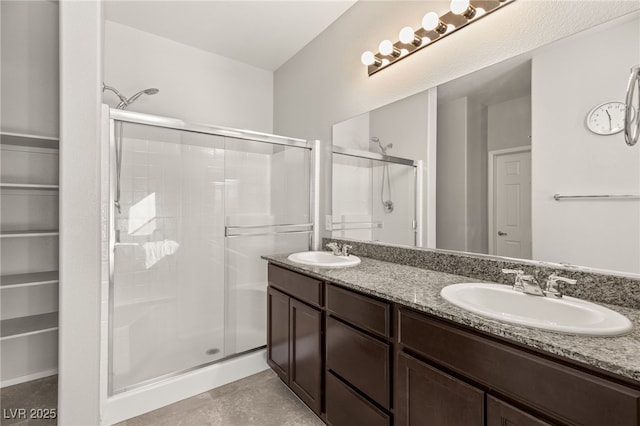 bathroom featuring a shower with shower door and vanity