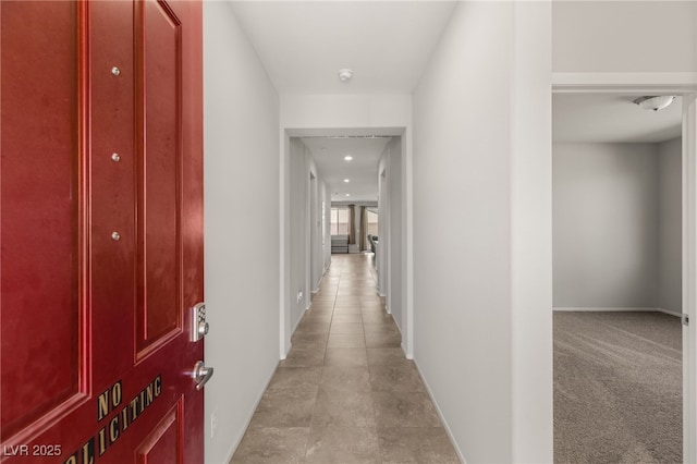 hallway featuring light colored carpet