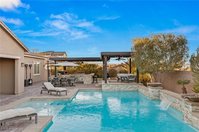 view of pool with exterior kitchen, a patio area, a grill, ceiling fan, and pool water feature