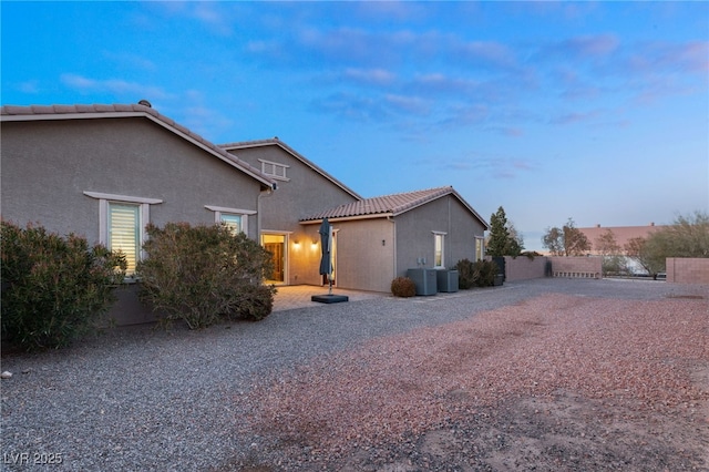 property exterior at dusk featuring central air condition unit