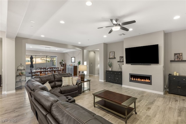 living room featuring light hardwood / wood-style floors and ceiling fan