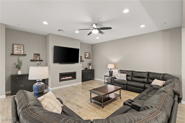 living room featuring ceiling fan and light hardwood / wood-style flooring