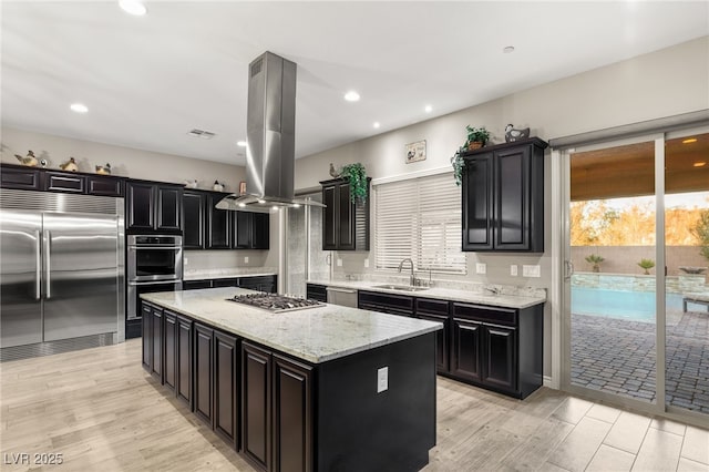 kitchen with a center island, stainless steel appliances, light hardwood / wood-style floors, sink, and island range hood