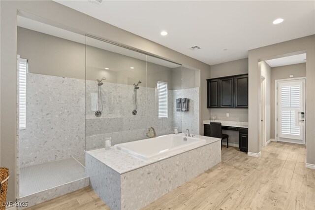 bathroom featuring wood-type flooring, vanity, and separate shower and tub