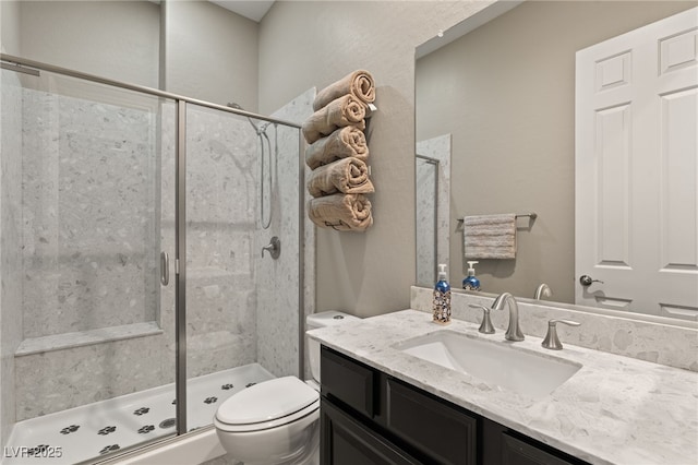 bathroom featuring toilet, an enclosed shower, and vanity