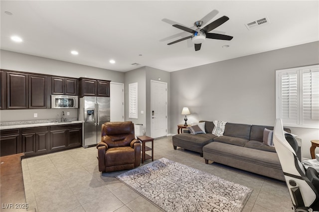 living room with ceiling fan, light tile patterned floors, and sink