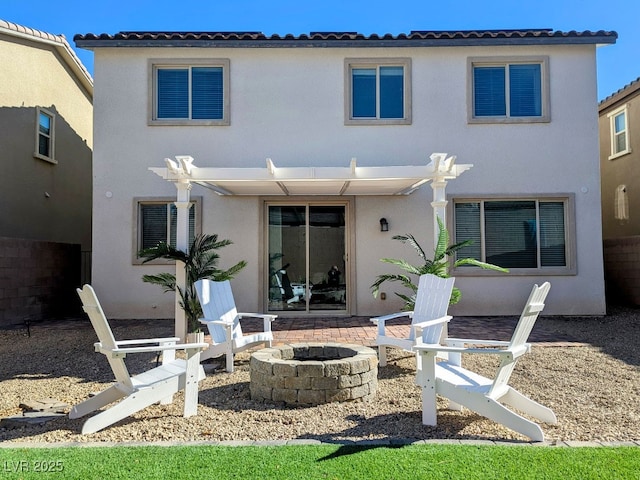 rear view of property featuring a pergola, a patio area, and a fire pit