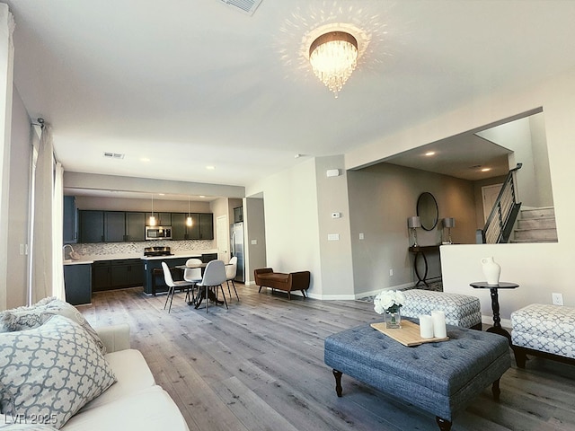 living room with light hardwood / wood-style flooring and a chandelier