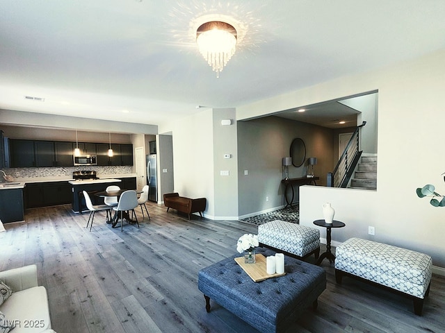 living room with light hardwood / wood-style flooring and sink