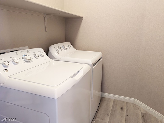 washroom with light hardwood / wood-style floors and washer and clothes dryer