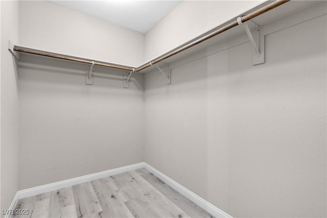 walk in closet with light hardwood / wood-style floors