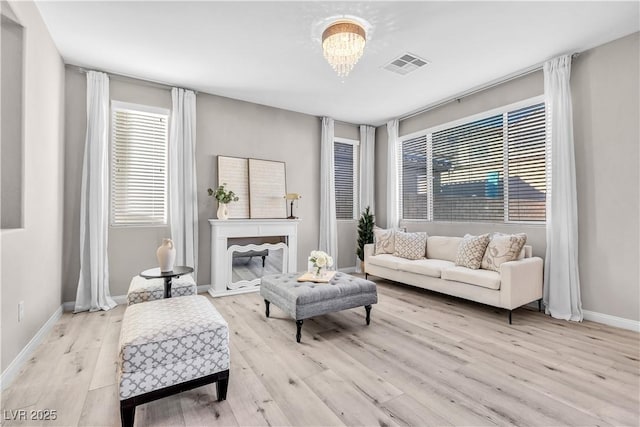 sitting room featuring a notable chandelier and light wood-type flooring