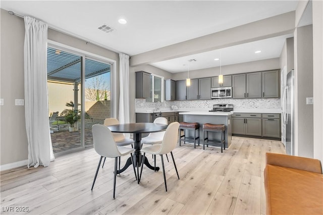 dining area featuring sink and light wood-type flooring