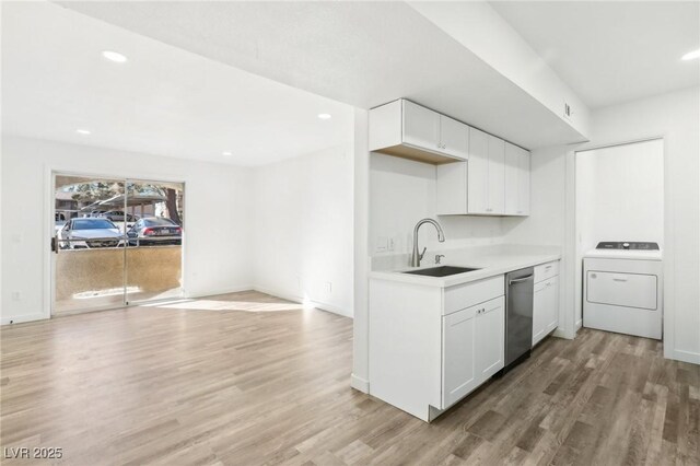 kitchen with white cabinetry, stainless steel dishwasher, washer / clothes dryer, and sink