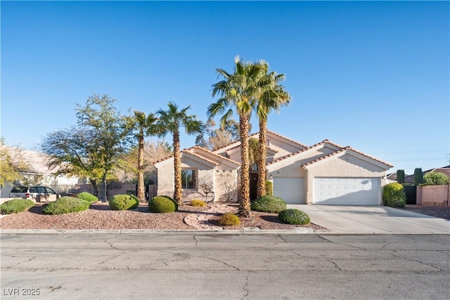 view of front facade featuring a garage, concrete driveway, stucco siding, and a tile roof