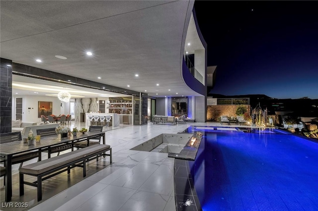 pool at twilight featuring a notable chandelier