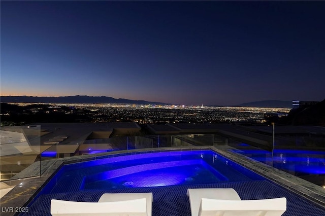 pool at dusk featuring a mountain view