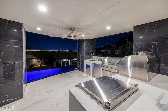 patio at night with sink and area for grilling