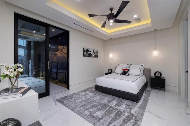 bedroom featuring access to outside, ceiling fan, and a tray ceiling