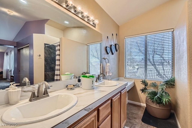 bathroom with walk in shower, vanity, vaulted ceiling, and a wealth of natural light