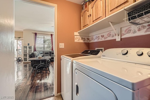 laundry area with cabinets, wood-type flooring, and washing machine and dryer