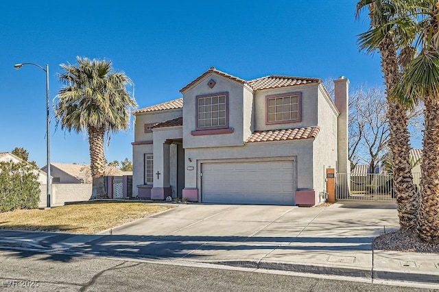 mediterranean / spanish home featuring a garage, driveway, a tiled roof, a gate, and stucco siding