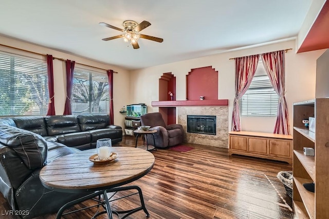 living room with ceiling fan, hardwood / wood-style floors, and a tiled fireplace