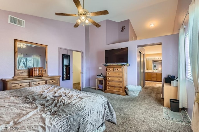 carpeted bedroom featuring ceiling fan, a closet, high vaulted ceiling, and ensuite bath